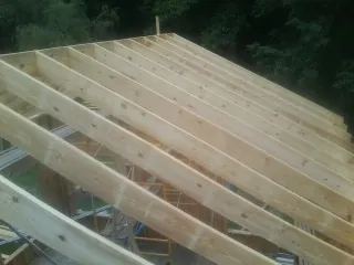 New roof rafters set over an addition before sheathing in Bigfork